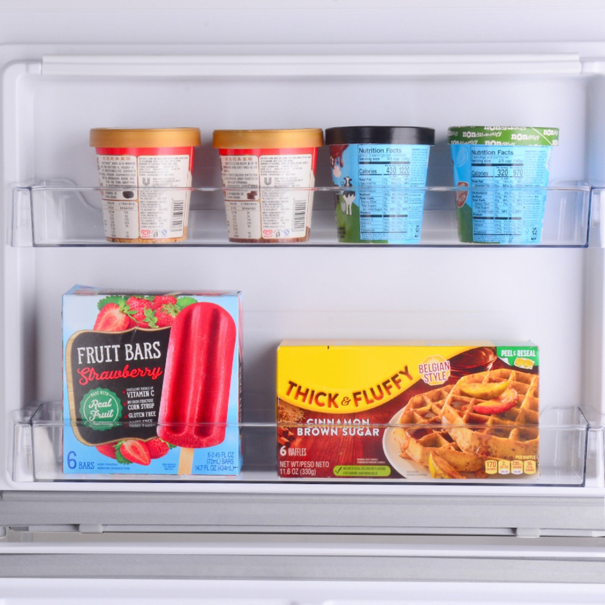 Closeup of the door bins in the freezer section of the Kenmore stainless steel top mount refrigerator filled with food items