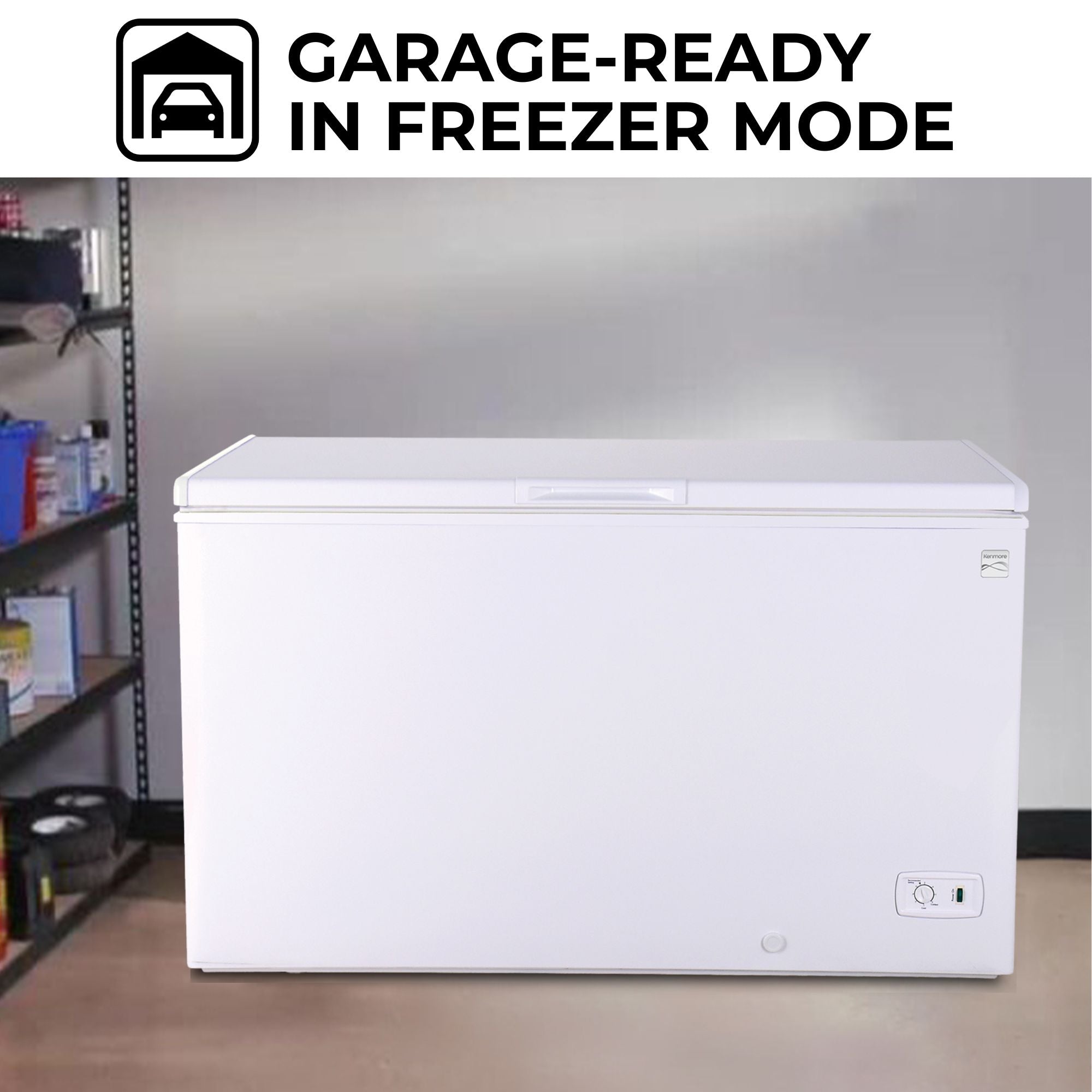Kenmore chest freezer, closed, in a garage with a light gray wall behind and a black metal utility shelf to the left.