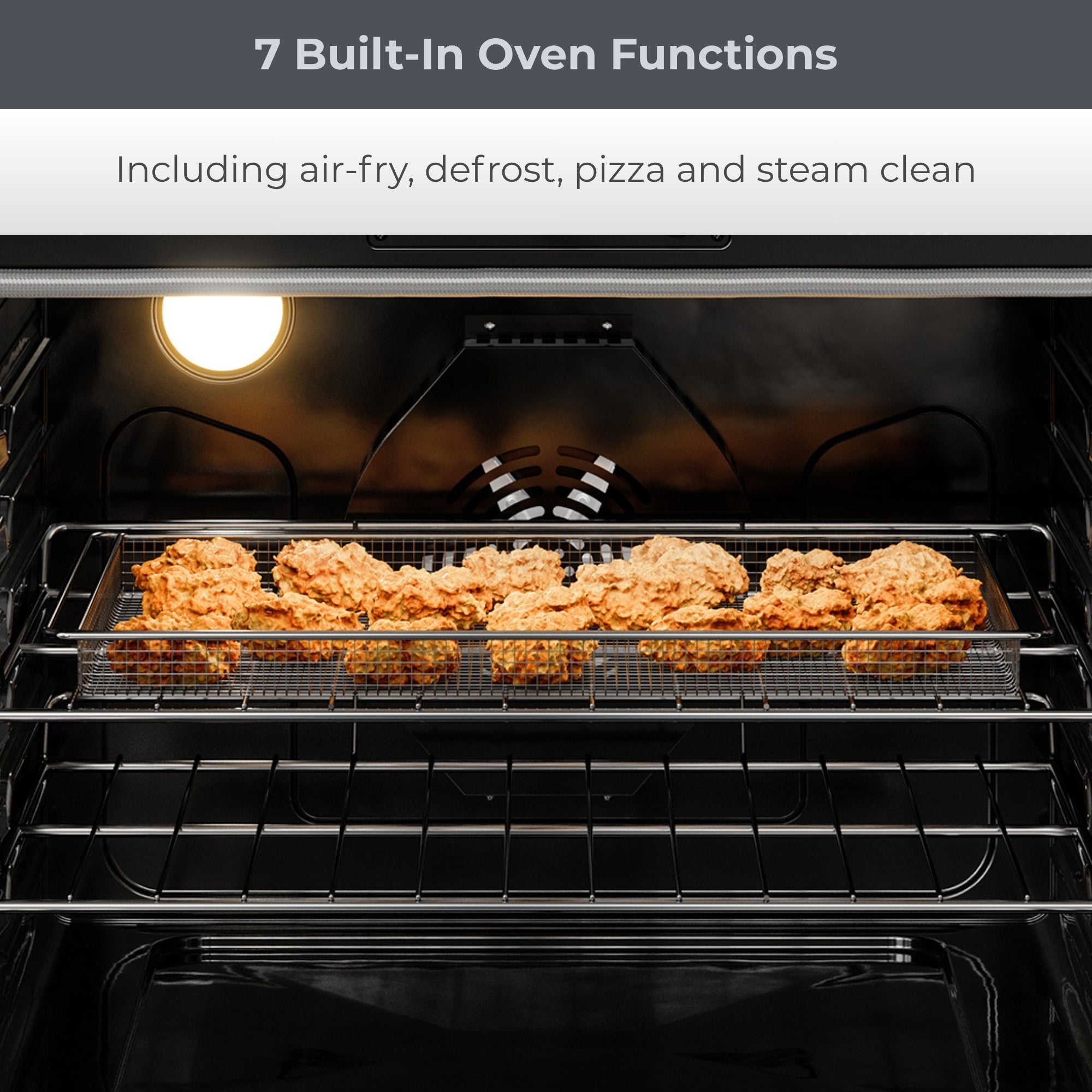 Closeup view of the open Kenmore PRO stainless steel front-control range with crispy chicken wings in the air fryer basket inside. Text above reads, "7 Built-In Oven Functions: Including air-fry, defrost, pizza and steam clean"
