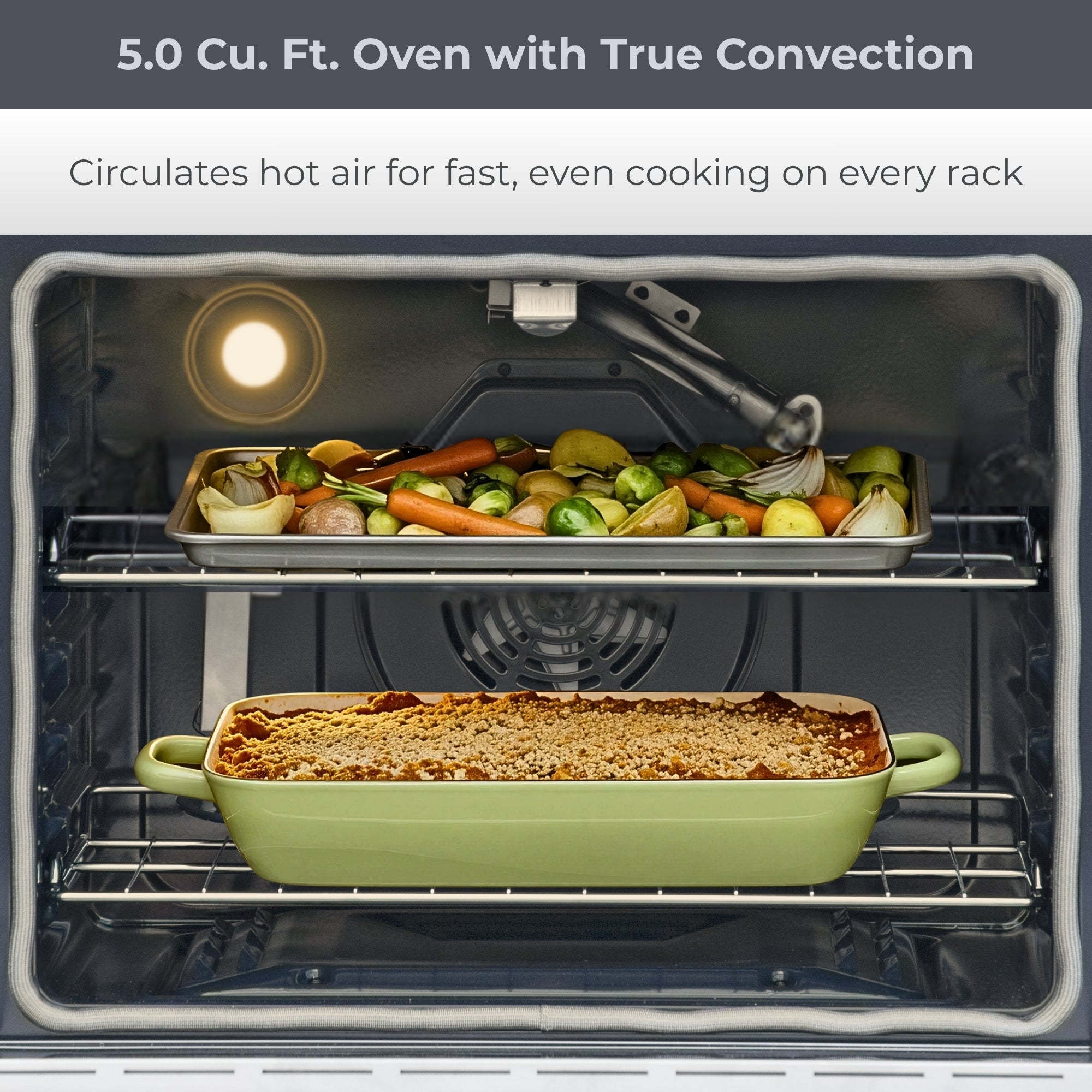 Closeup view of the open Kenmore PRO stainless steel front-control range with food cooking on both chrome oven racks. Text above reads, "5.0 Cu. Ft. Oven with True Convection: Circulates hot air for fast, even cooking on every rack"