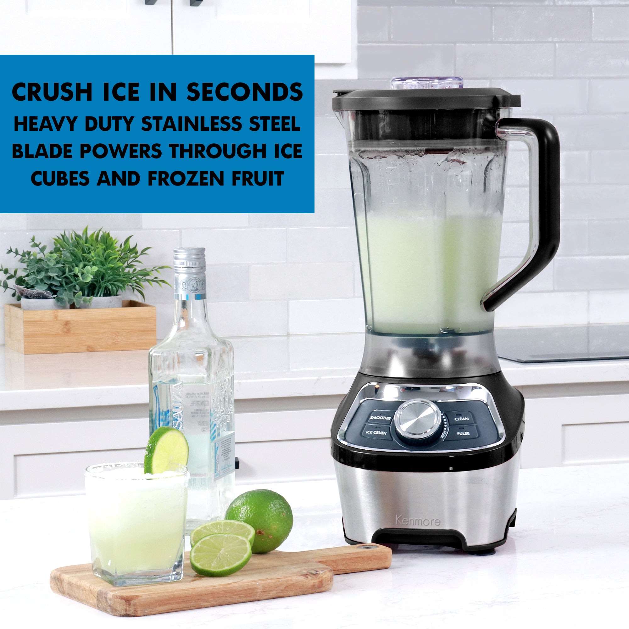 1.9 liter capacity blender filled with a light green frozen beverage on a white kitchen counter with a clear glass bottle and sliced lime and a glass of frozen blended margarita with a salted rim on a wooden cutting board beside it. Text overlay reads Crush ice in seconds: Heavy duty stainless steel blade powers through ice cubes and frozen fruit.