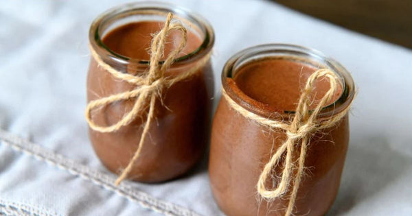 Picture of two small glass jars filled with smooth chocolate mouse and decorated with a twine bow