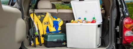 P27 camping cooler plugged into the trunk of a suv vehicle next to fishing gear