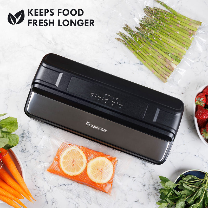 Kenmore vacuum food sealer on a white and gray marble surface surrounded by fresh foods and bags of vacuum sealed foods. Text above reads, "KEEPS FOOD FRESH LONGER"