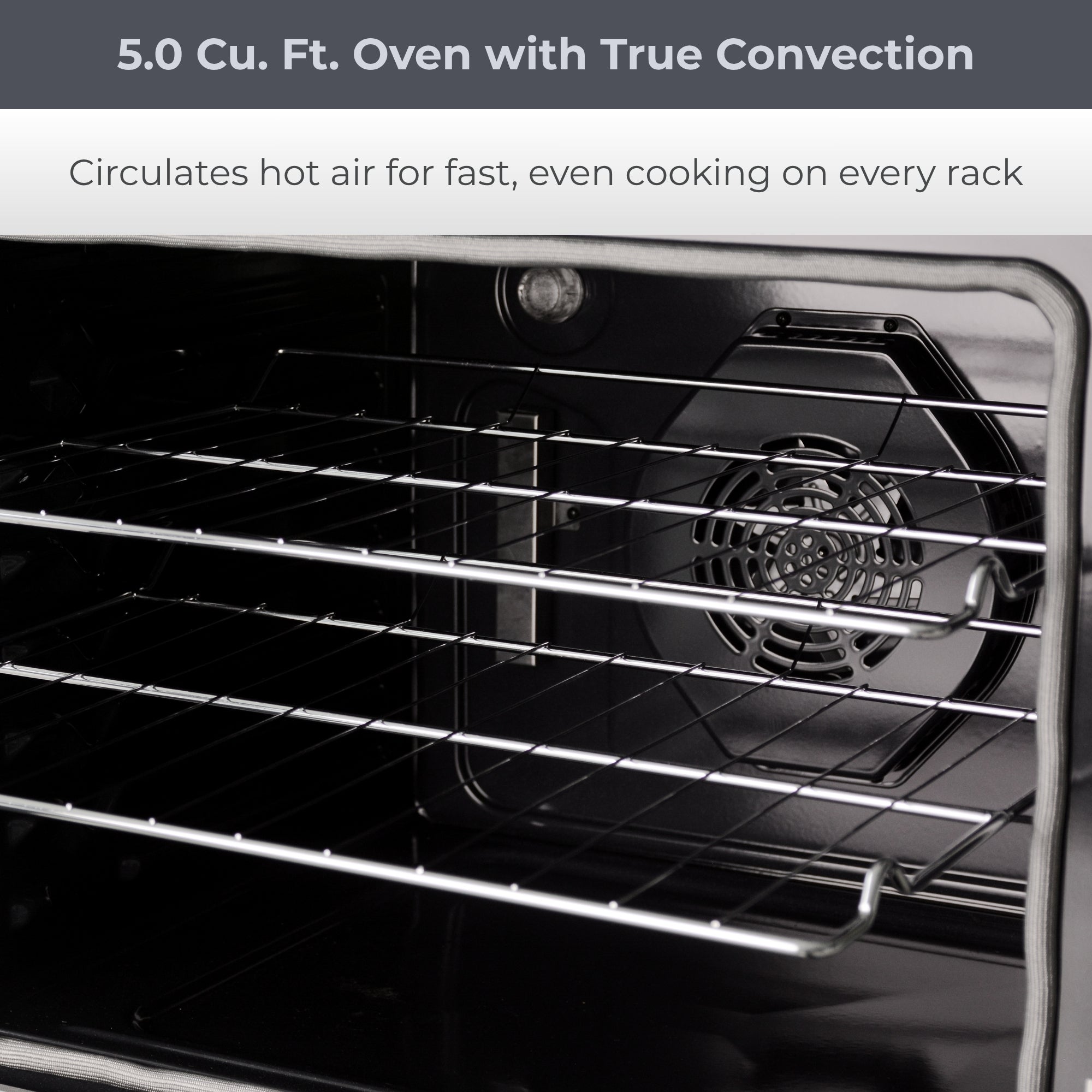 Closeup view of the open Kenmore PRO stainless steel front-control range showing the chrome oven racks partly pulled out and the convection fan at the back. Text above reads, "5.0 Cu. Ft. Oven with True Convection: Circulates hot air for fast, even cooking on every rack"