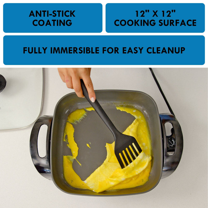 A person's hand using a spatula to cook an omelet in the Kenmore non-stick electric skillet with features listed above: Anti-stick coating; 12" x 12" cooking surface; fully immersible for easy cleanup.