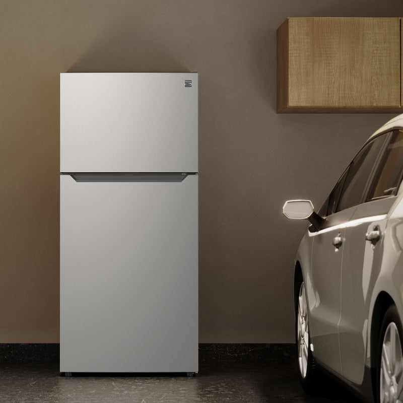 Kenmore 18.1 cu ft metallic steel top mount refrigerator beside a silver car in a garage