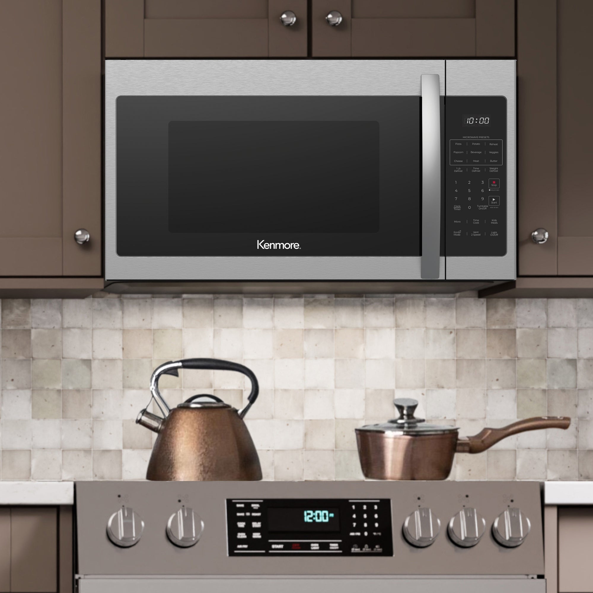 Kenmore over-the-range microwave installed between taupe cupboards. There is a smooth-top range below with a copper pot and kettle on it and a cream tile backsplash behind.