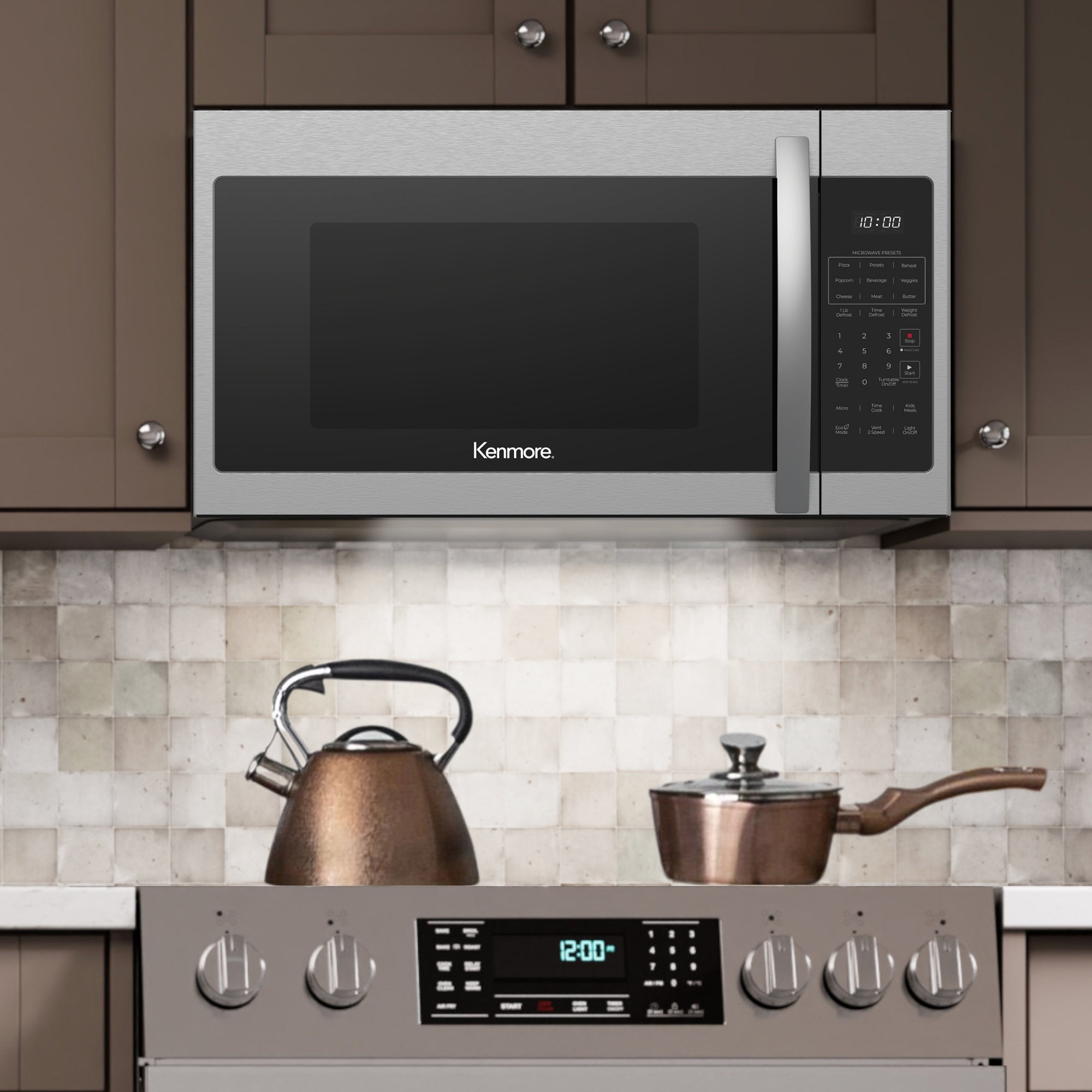 Kenmore over-the-range microwave installed between taupe cupboards with the under-cabinet task lighting turned on and a copper kettle and pot on a range below it.