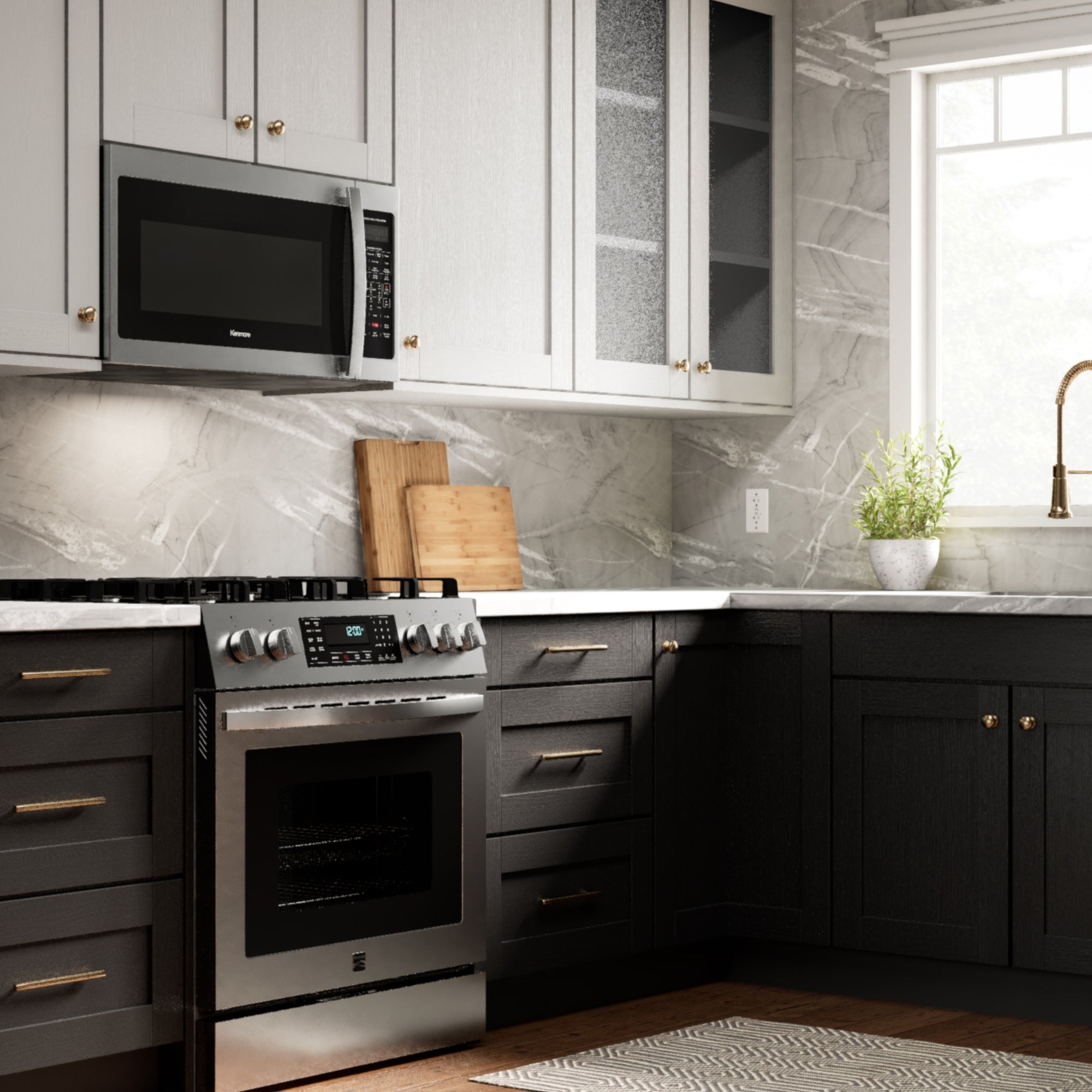 Kenmore over-the-range microwave installed in a bright modern kitchen with a stainless steel range and black and white cupboards.