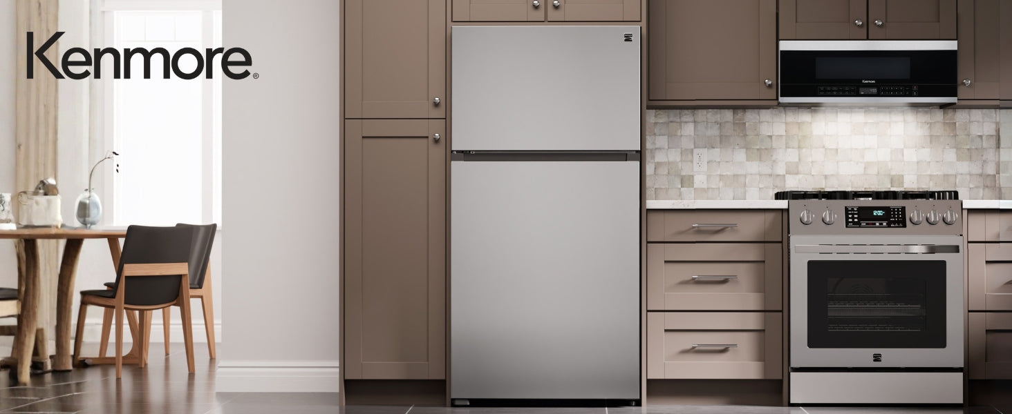 Kenmore over-the-range microwave installed in a bright modern kitchen with a stainless steel range and taupe cupboards.