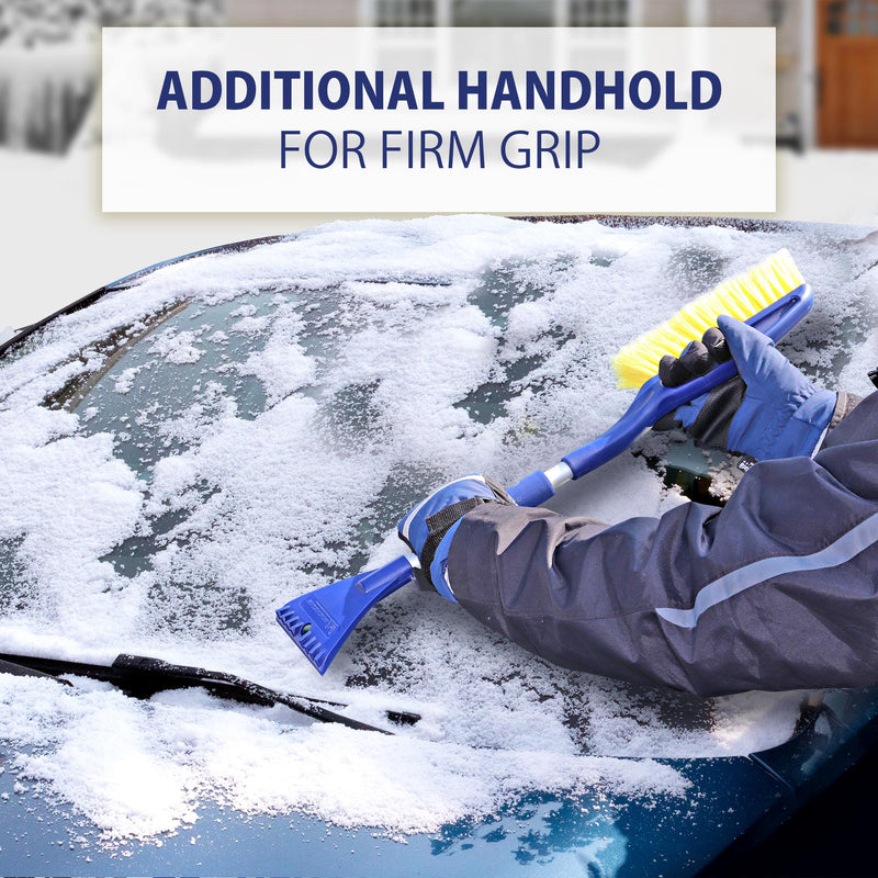Lifestyle image of a person in winter clothing holding the snow brush with both hands and using the ice scraper to scrape the windshield of a dark coloured car. Transparent white overlay at the top contains text "Additional handhold for firm grip"