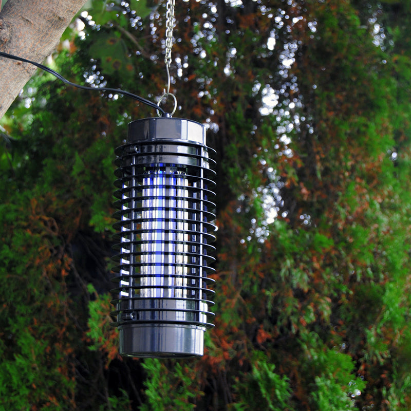 Lifestyle image of the Bite Shield electronic flying insect zapper hanging from a tree branch with a background of leaves and branches