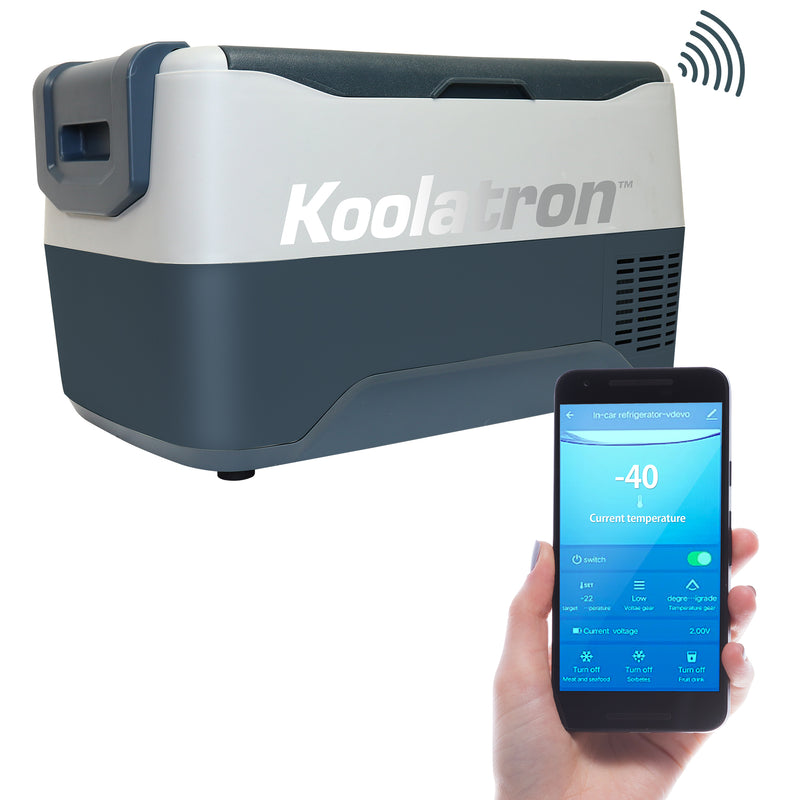 Product shot of the Koolatron SK30 30L travel freezer/fridge with a hand holding a smartphone with the SmartKool app on the screen in the foreground