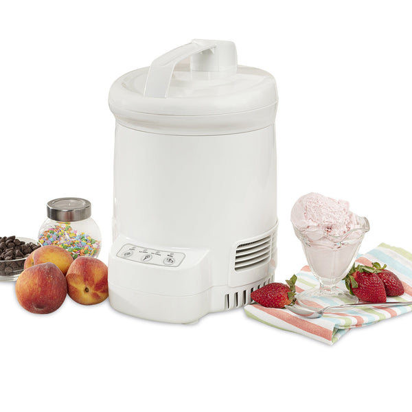 Product shot on white background of ice cream maker with a cup of light pink ice cream, strawberries, a spoon, and a striped napkin to the right and peaches, a jar of sprinkles, and a bowl of chocolate chips to the left.