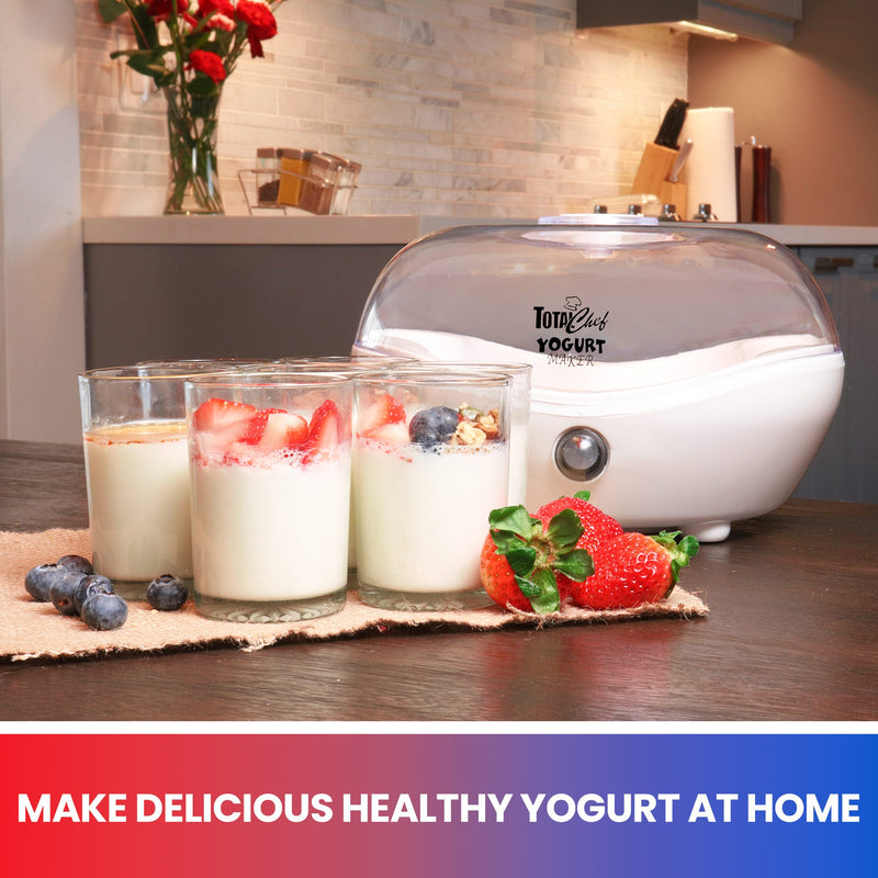 Lifestyle image of empty and closed yogurt maker on a dark brown wooden table. There are 3 cups of plain yogurt with berry and granola toppings and several strawberries and blueberries on a piece of light brown fabric beside it. Text below reads, "Make delicious healthy yogurt at home"